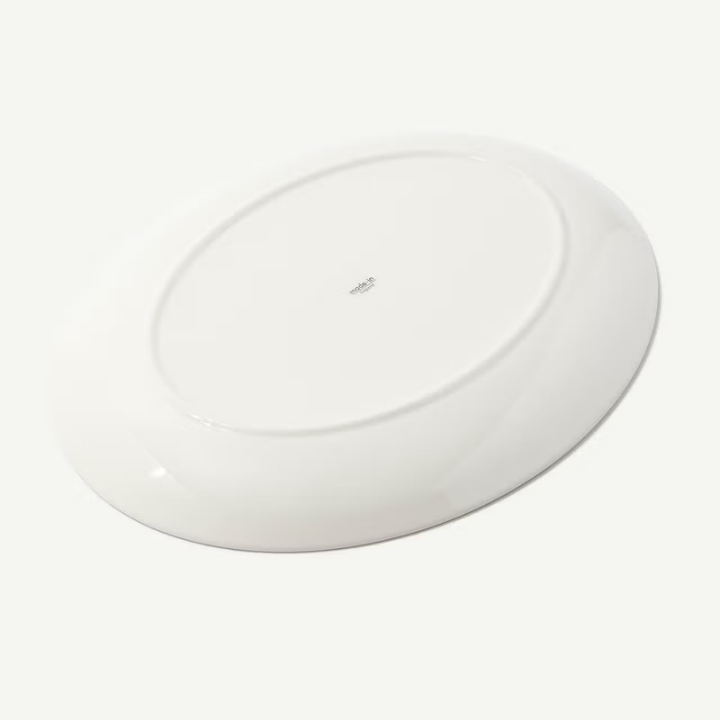 A glossy white ceramic plate shown from a top-down perspective on a clean white background.
