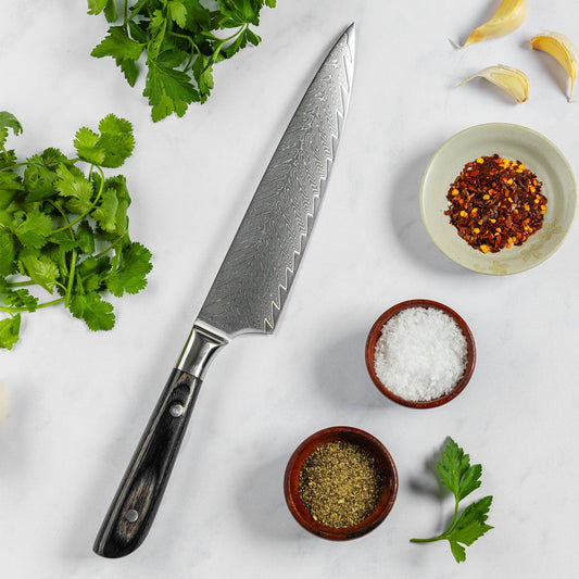 Knife on white surface with spices and herbs.