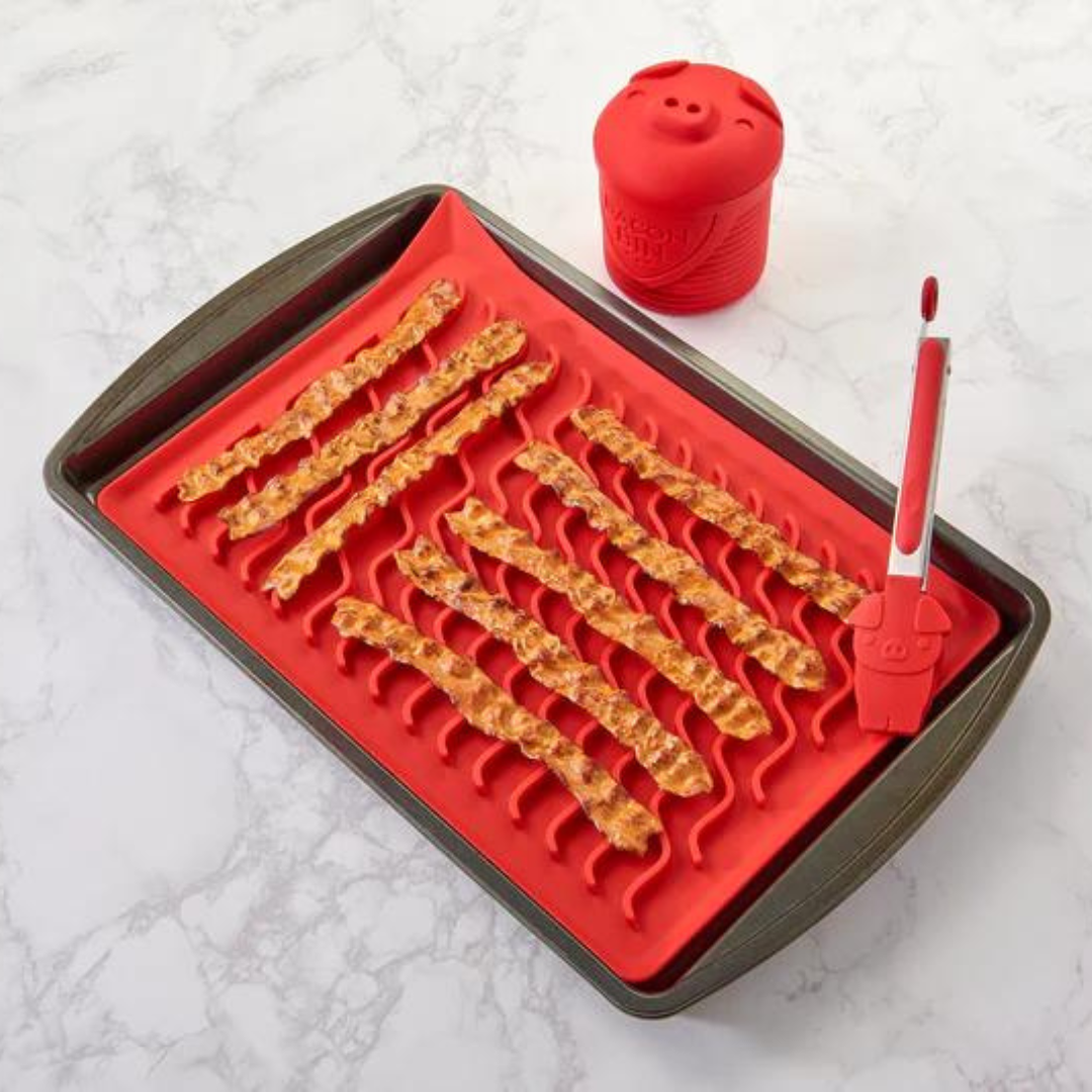 Red Oven Bacon Mat with strips of bacon and tongs and a red grease container.