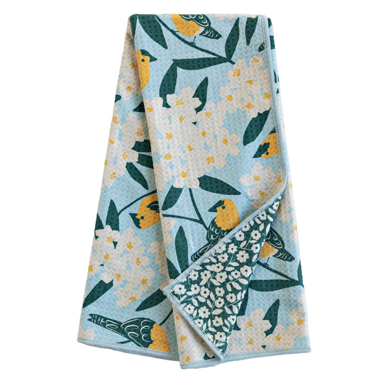 Folded towel with floral and bird pattern on a white background