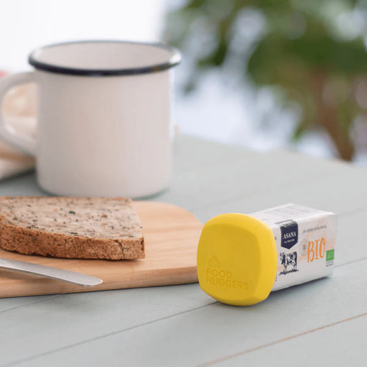 Yellow Butter Hugger on a stick of butter at breakfast table.
