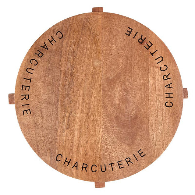 Crafted from mango wood with a stylish footed base and the word "charcuterie" elegantly etched around the top. This board is not just a serving piece but a statement of culinary sophistication. Perfect for presenting an assortment of cheeses, cured meats, fruits, and nuts, it adds a touch of rustic charm to any dining occasion. Ideal for entertaining or everyday use, this versatile board enhances your table setting with its natural beauty and practical design.
