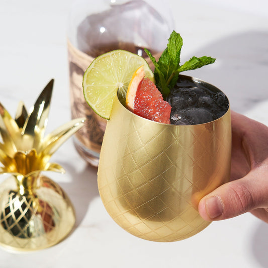 A tumbler so decorative you won't even need a garnish. Enjoy Mai Tais out of this gorgeous gold pineapple. Complete with etched details and a lid crowned with delicate fronds, it’s a stunning statement piece for serving any cocktails.