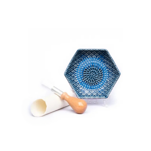 The Grate Plate is a ceramic grating plate used to grate garlic, ginger, peppers, nutmeg, chocolate, hard cheeses and much more! Perfect for adding fresh flavor to any dish. It's easy to clean and can be reused for an endless variety of culinary creations. Plus, the handy silicone garlic peeler and gathering brush make prepping fast and mess-free!