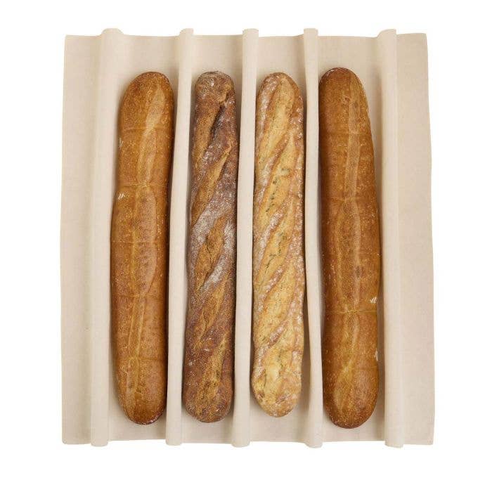 Four baguettes in a white container on a white background