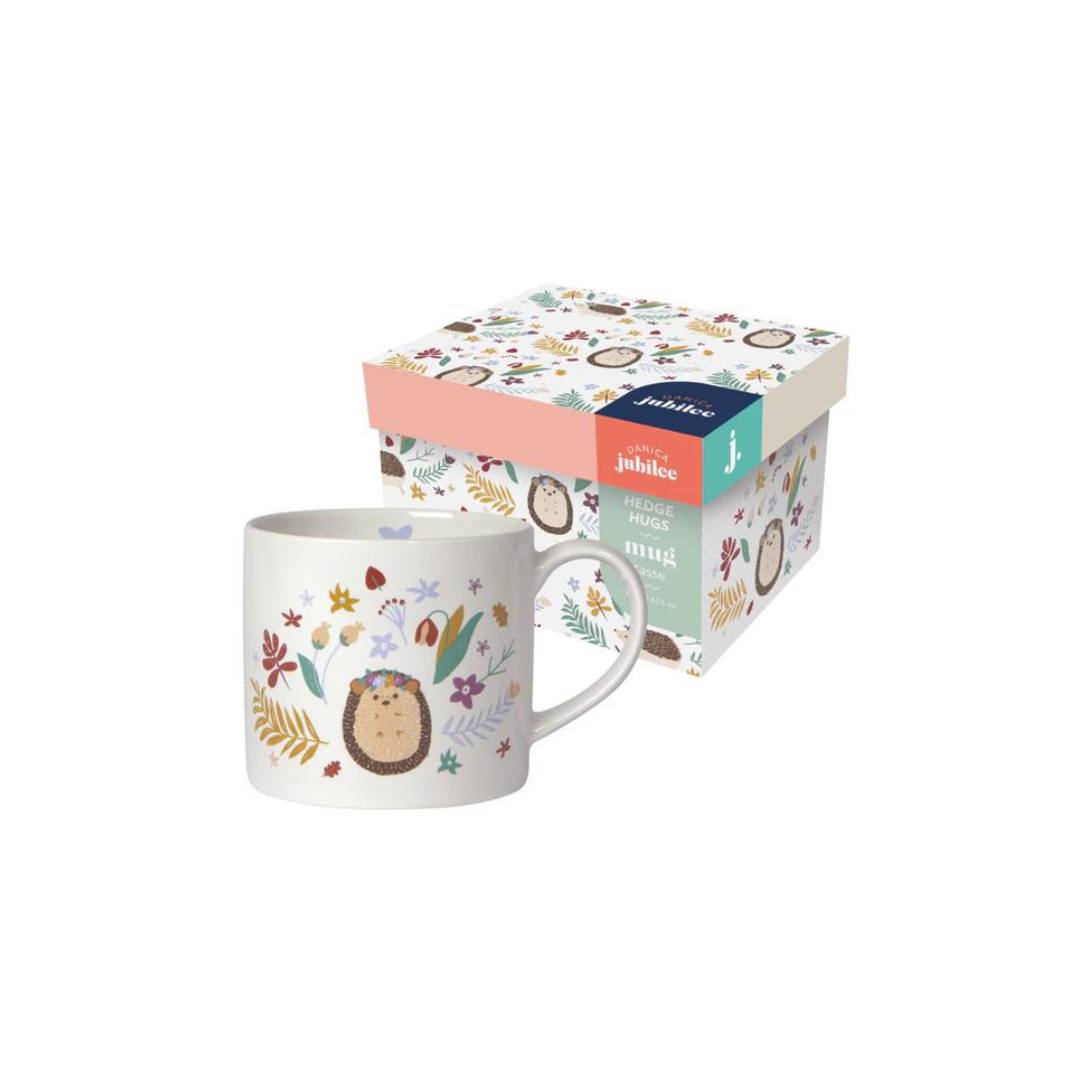 "Hedge Hugs" Mug in a Box brings a cozy, nature-inspired charm to your mornings. Featuring a whimsical hedgehog surrounded by wildflowers and a smooth white interior,