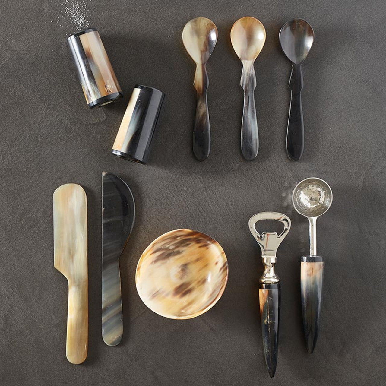 These horn cheese spreaders, hand-crafted from Indian buffalo horns, are unique, one-of-a-kind table accessories. Skilled artisans transform the horns into these beautiful and functional pieces, adding a touch of elegance to your cheese board. Each set of two spreaders varies slightly in color and shape, making them truly special.