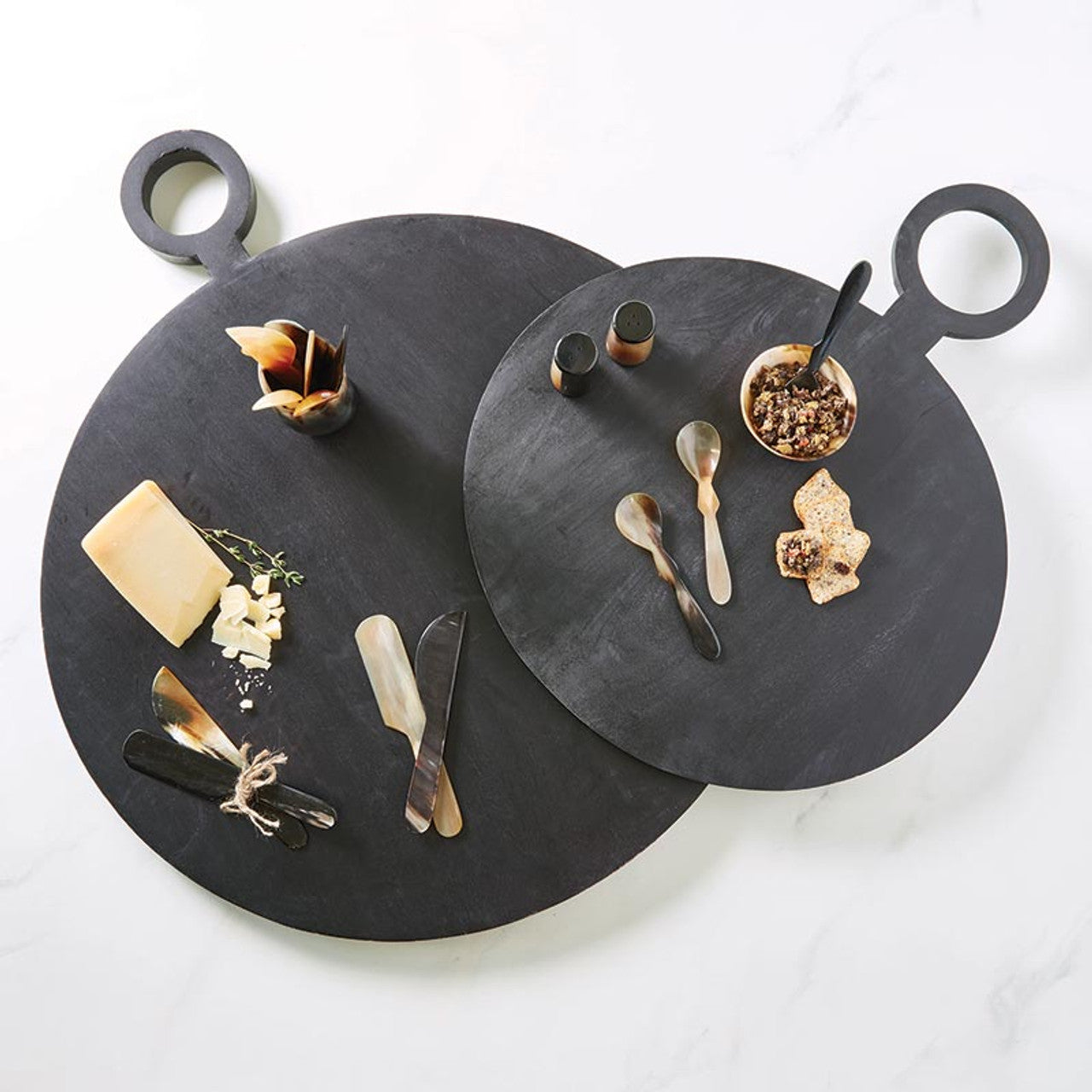 These horn cheese spreaders, hand-crafted from Indian buffalo horns, are unique, one-of-a-kind table accessories. Skilled artisans transform the horns into these beautiful and functional pieces, adding a touch of elegance to your cheese board. Each set of two spreaders varies slightly in color and shape, making them truly special.