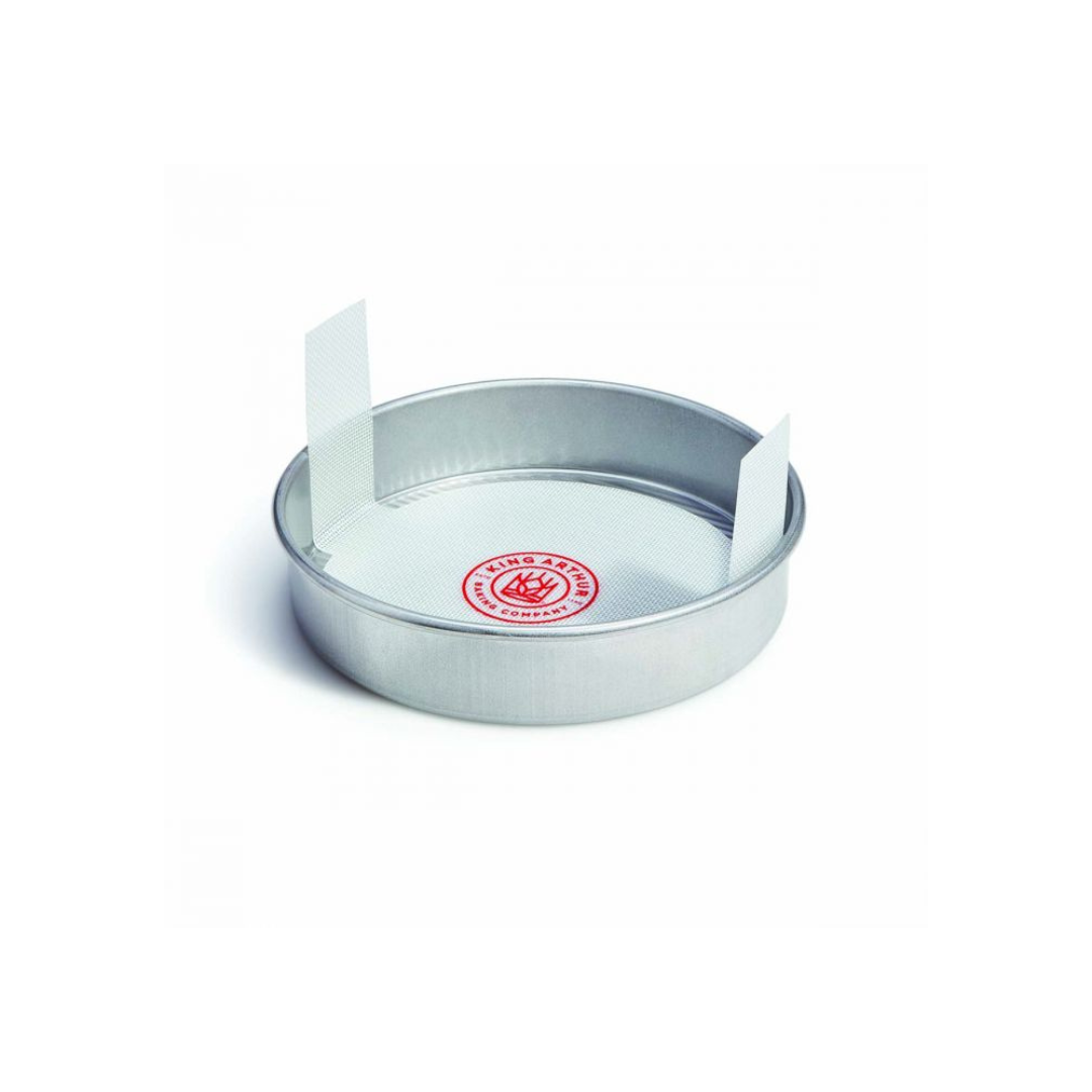 White round loaf lifter in a round metal cake pan
