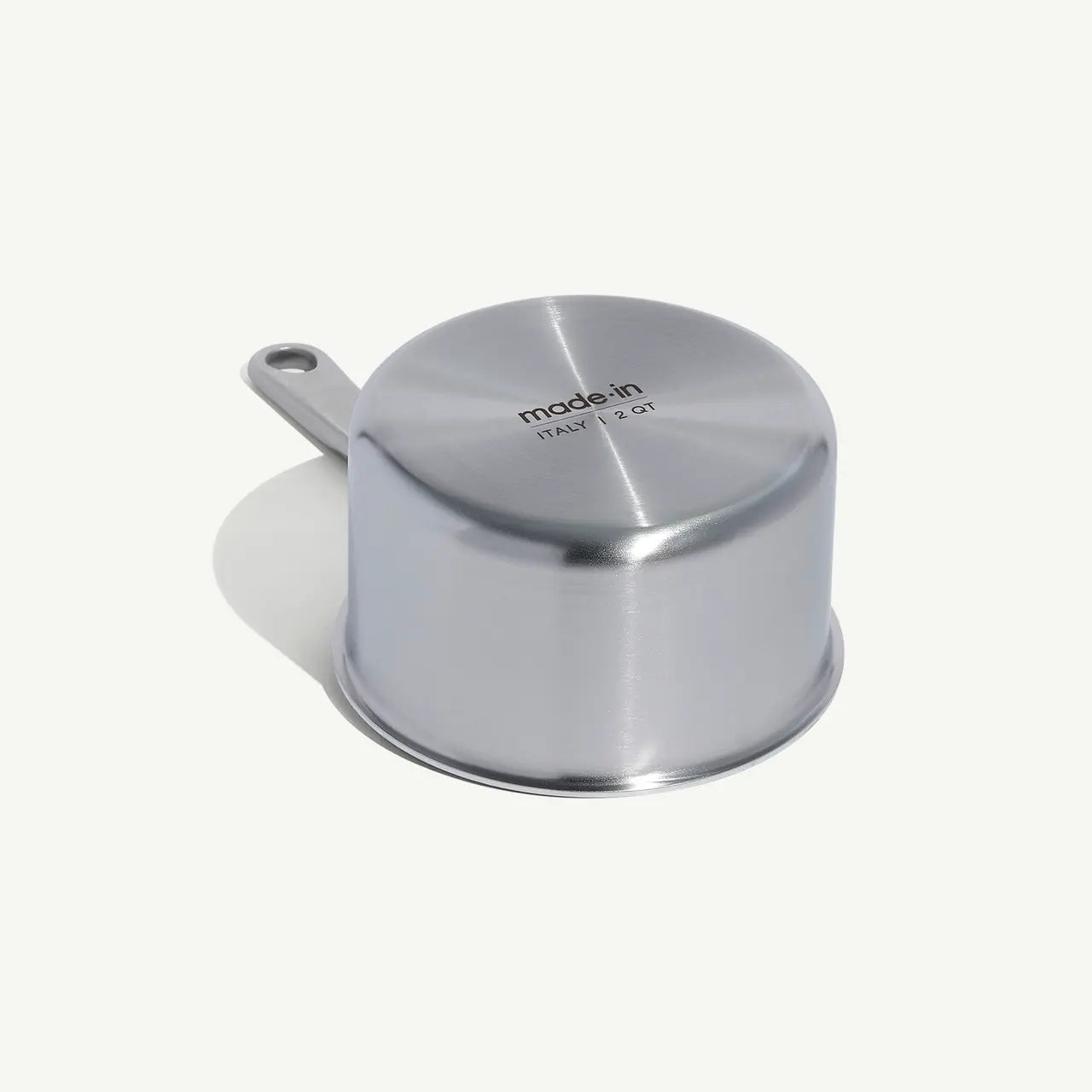 A stainless steel saucepan with a long handle, set against a white background.