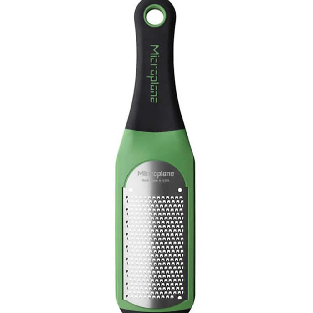 Green and black Microplane grater on a white background