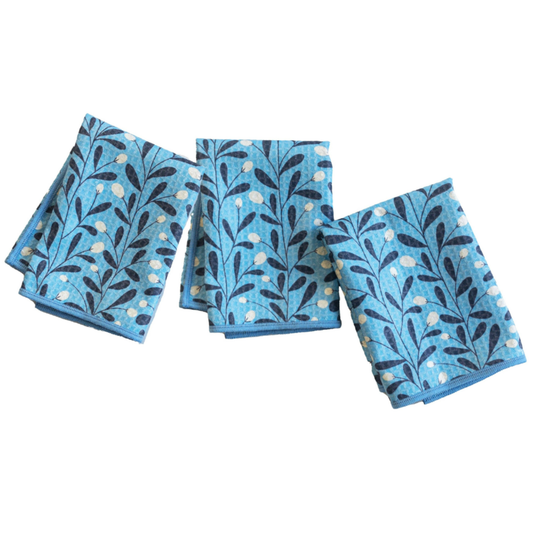 Set of three blue napkins with leaf pattern on a white background