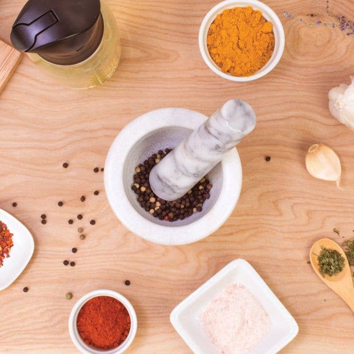 Mortar and pestle with spices on a wooden surface