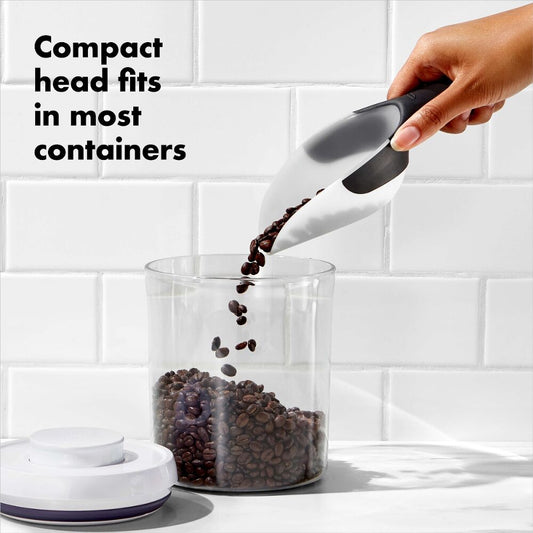 Hand using a compact head to pour coffee beans into a container with text 'Compact head fits in most containers'.