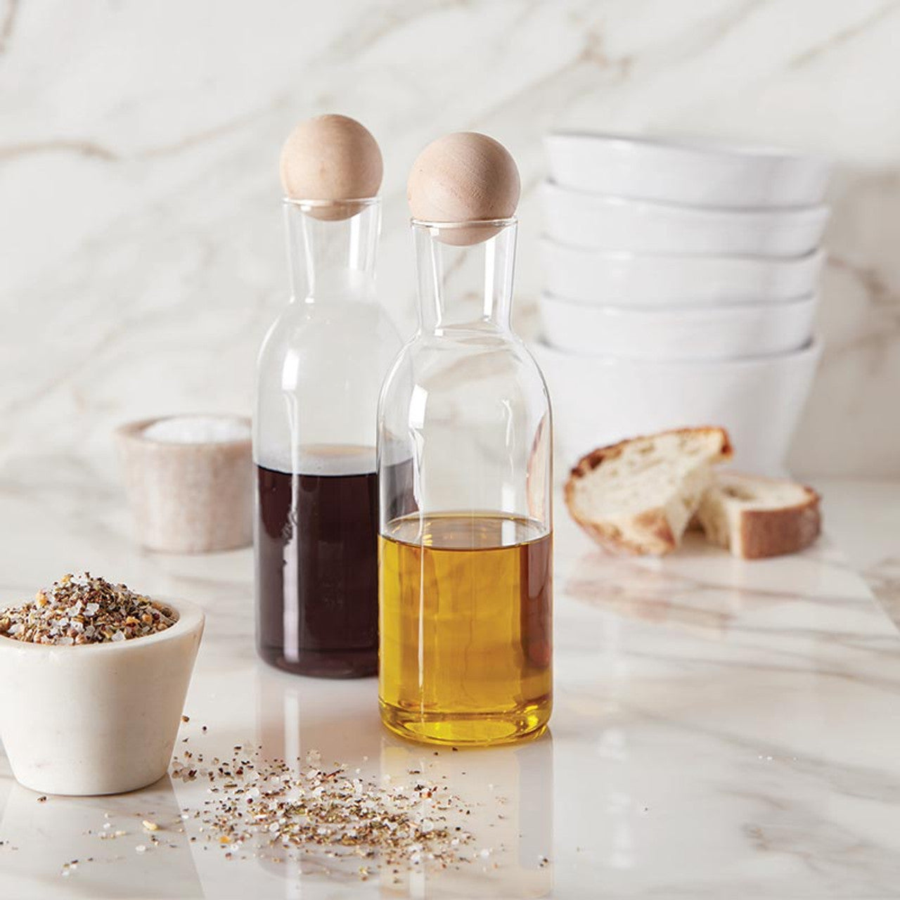 Add a dash of elegance to your kitchen with this chic Oil & Vinegar Carafe! Featuring a sleek design and a stylish wood ball stopper, it's perfect for storing and serving your favorite oils and vinegars. Elevate your culinary experience with this beautiful addition to your kitchen!