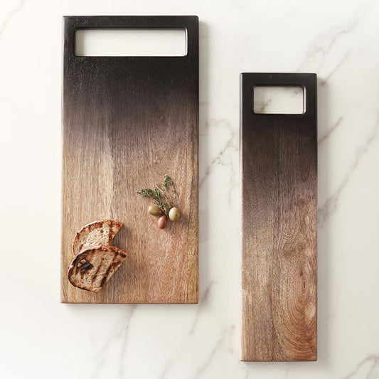 Bring a touch of bold sophistication to your kitchen with our Ombre Serving Board - 19" x 9"! This eye-catching tray features a stunning black and natural ombre finish, making it a standout accent for any table. Perfect for serving your favorite breads or adding a stylish touch to your dining experience, this board blends modern design with practical elegance.