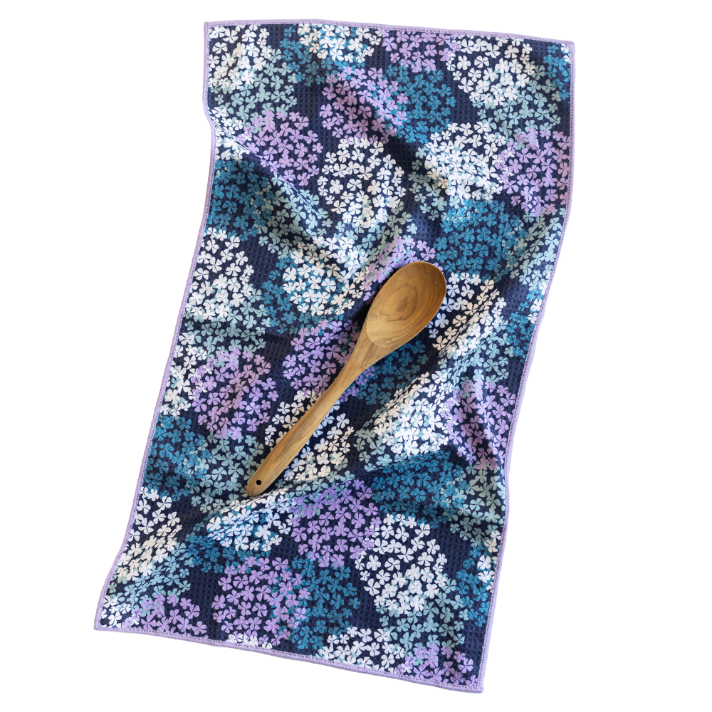 Floral patterned towel with a wooden spoon on a white background