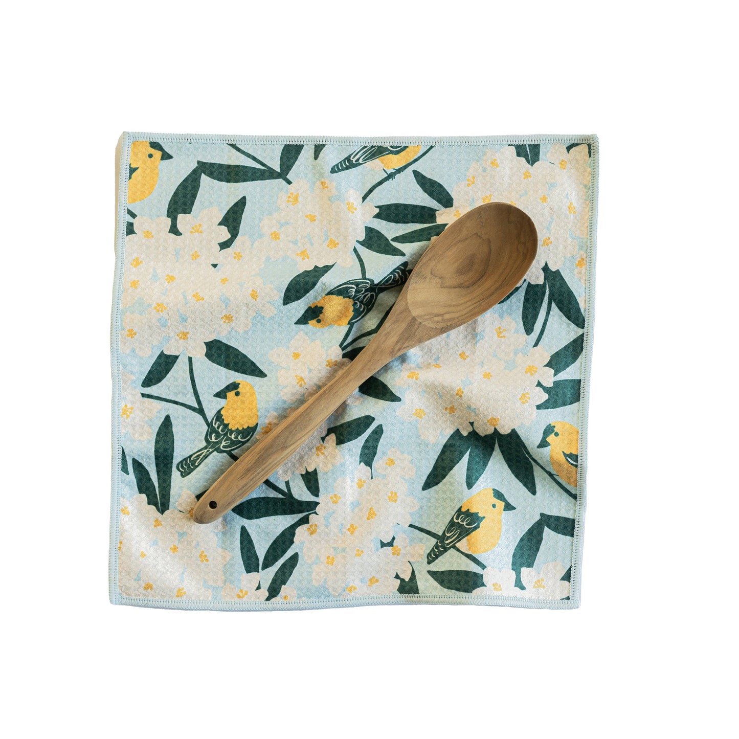 Floral patterned towel with a wooden spoon on a white background