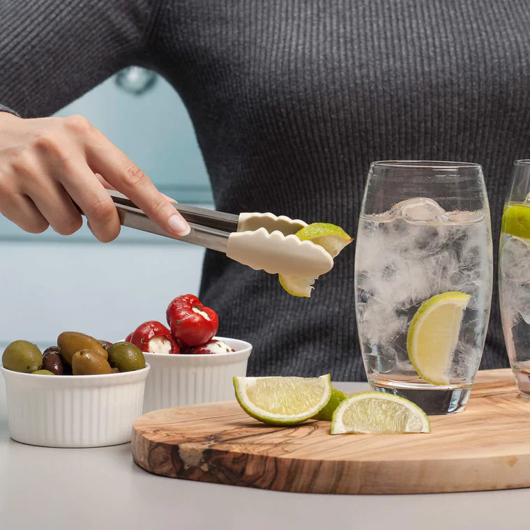 Grip, flip, and serve with ease using the Silicone Tongs in Coastal Cream! Featuring scalloped, non-scratch silicone tips, these premium kitchen tongs provide the perfect hold for everything from delicate greens to sizzling steaks. The brushed stainless steel handle offers durability, while the smart locking mechanism keeps them neatly stored when not in use.