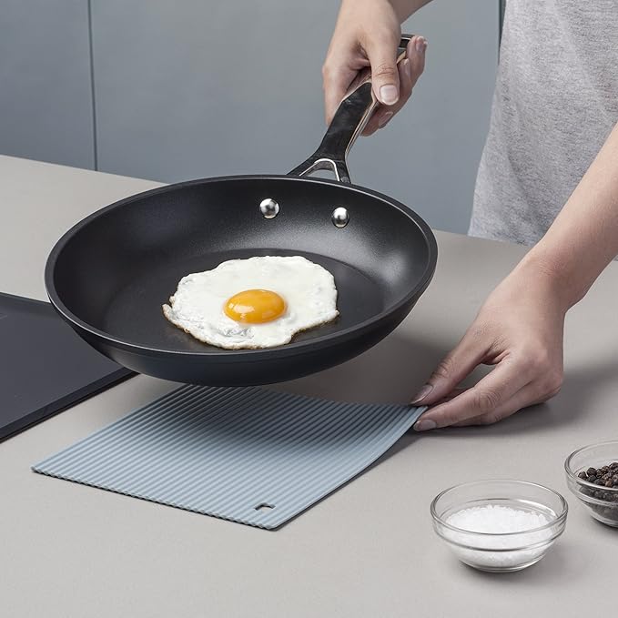 The Zeal Silicone Trivet Mat is the ultimate kitchen multitasker, protecting your countertops and tables from hot pots, pans, and dishes with its non-slip, heat-resistant design (up to 250ºC/482ºF). This 9" x 9" mat isn’t just for hot cookware—it doubles as a potholder, placemat, jar opener, or even a stabilizer for mixing bowls and cutting boards.