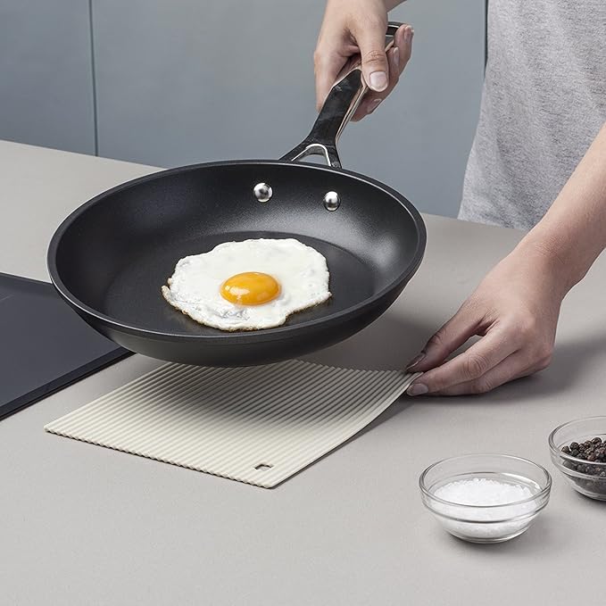 The Zeal Silicone Trivet Mat is the ultimate kitchen multitasker, protecting your countertops and tables from hot pots, pans, and dishes with its non-slip, heat-resistant design (up to 250ºC/482ºF). This 9" x 9" mat isn’t just for hot cookware—it doubles as a potholder, placemat, jar opener, or even a stabilizer for mixing bowls and cutting boards.