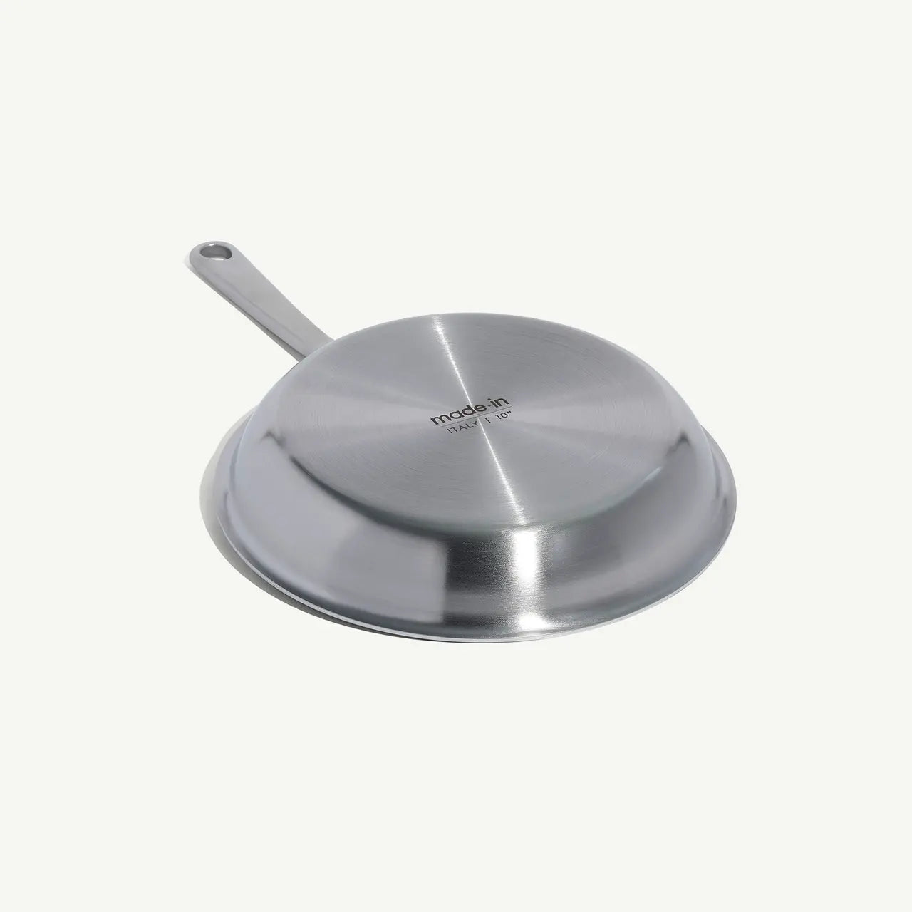 A upside down view of a stainless steel frying pan with a stay-cool handle.