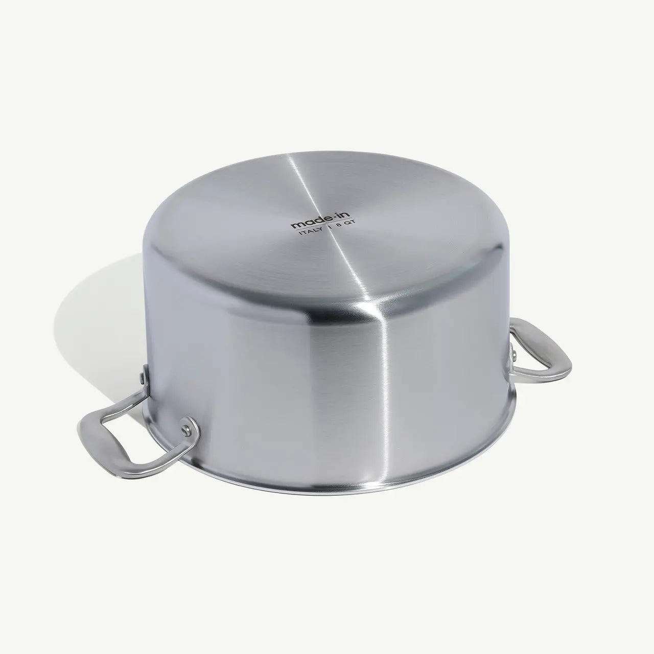A silver stainless clad stock pot with lid, featuring two handles and a fitted lid, on a white background.