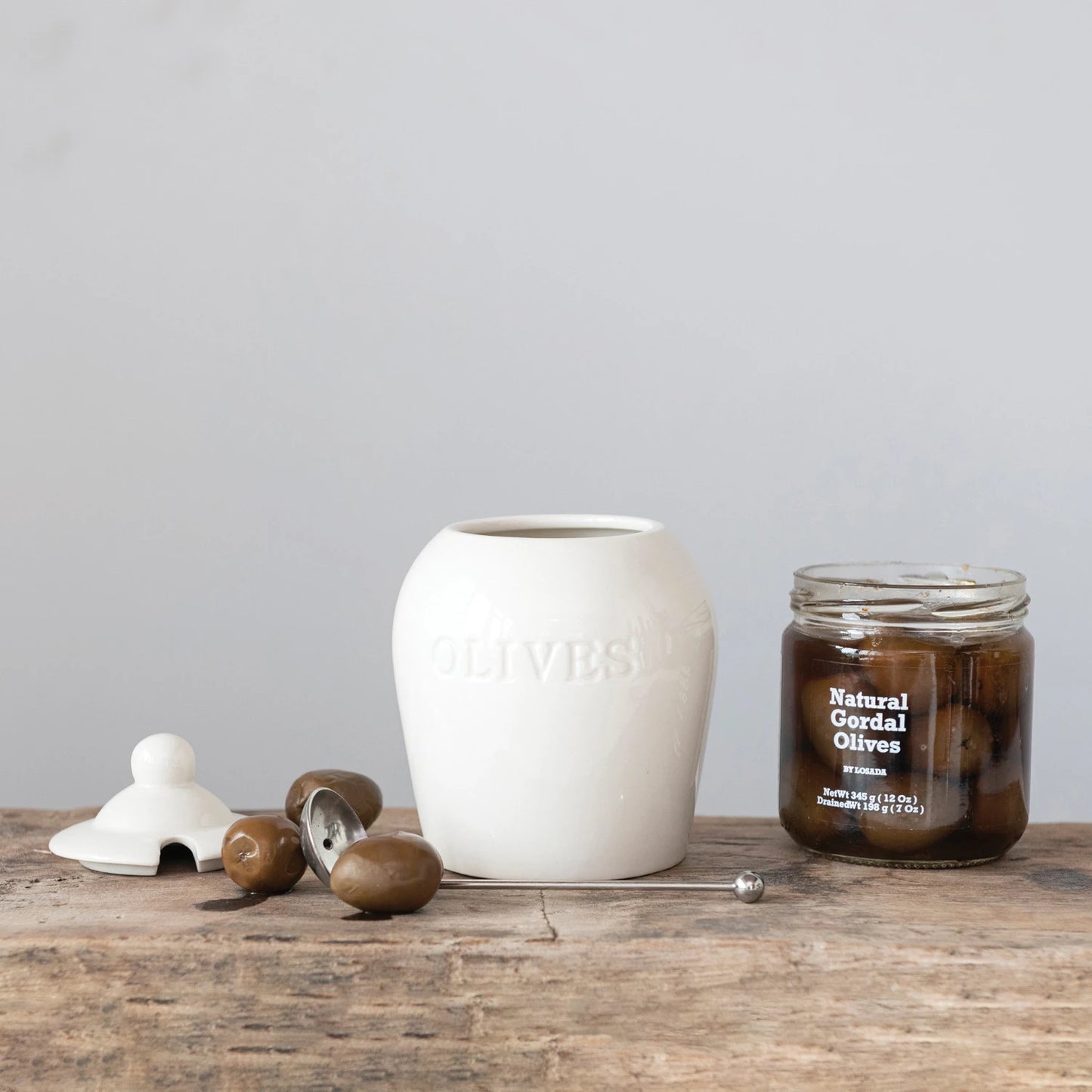 Enhance every kitchen storage with this 4-inch round debossed stoneware jars, each features a charming debossed design engraved with the word "Olives" and comes with a stainless steel slotted spoon.