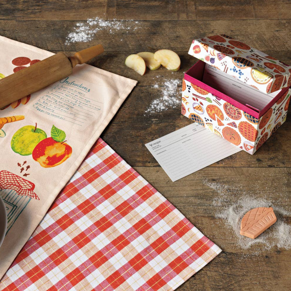 Baking-themed items including a pie, rolling pin, and recipe cards on a wooden table.
