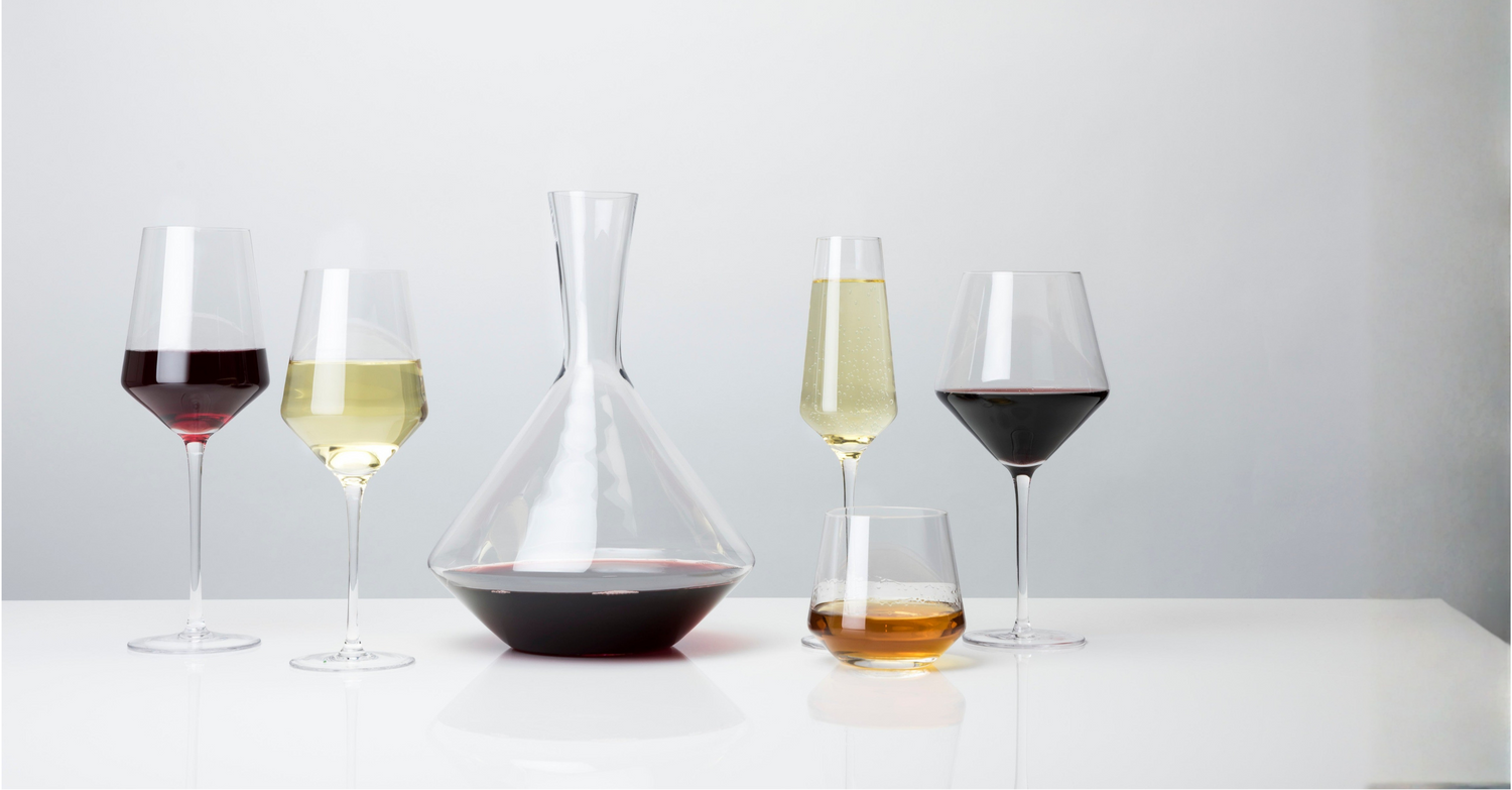 Wine glasses with different types of wine on a white surface