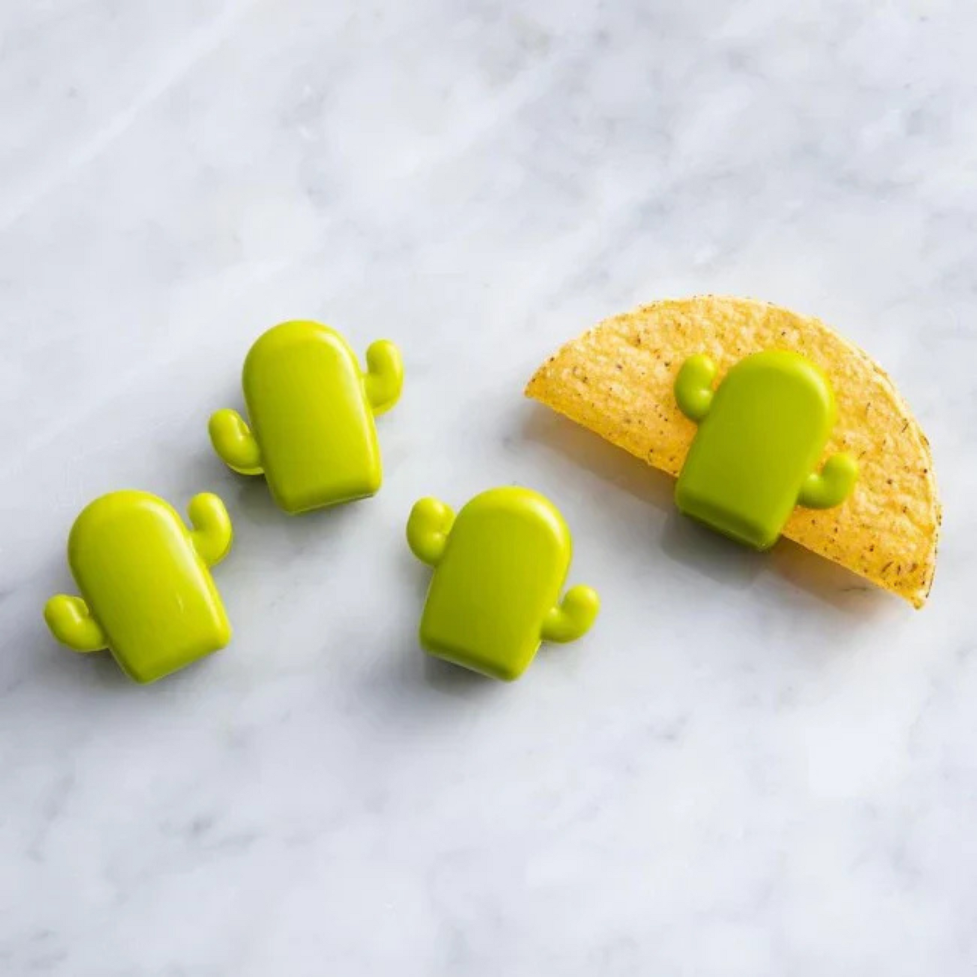 Four green cactus-shaped taco holders on a white background