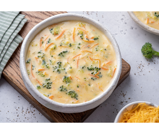 Broccoli cheese soup made in a Dutch Oven with cheddar, carrots, broccoli florets chopped, half and half or milk, and chicken broth! 