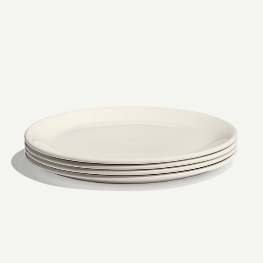 A stack of five plain white ceramic plates photographed on a clean white background with a soft shadow.