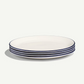 Set of four white plates with blue stripes on a white background