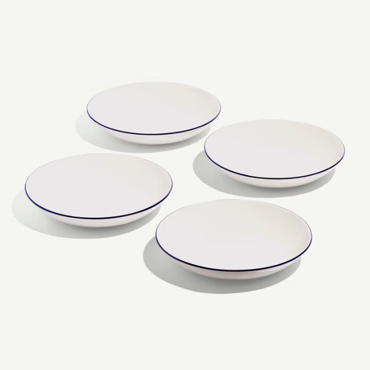 Four white plates with blue rims on a white background