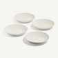 Four white ceramic bowls on a light gray background