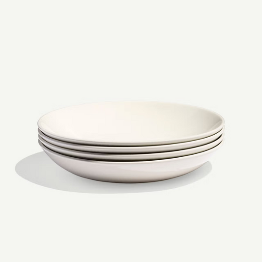 Set of four white ceramic bowls stacked on a white background