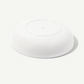 A white ceramic bowl shown from a high-angle perspective, photographed on a clean, solid off-white background.