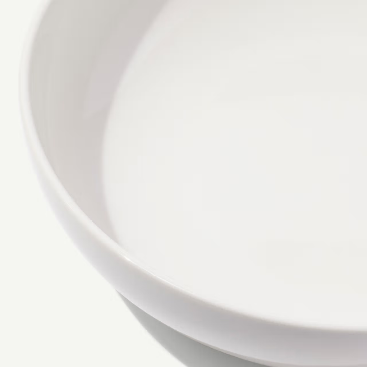 Close-up of a white ceramic bowl on a light gray background
