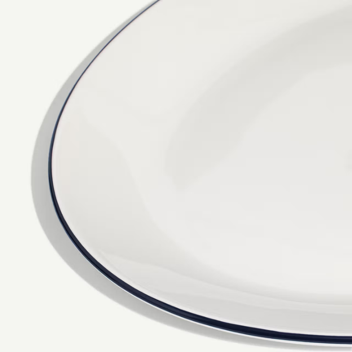 Close-up of a white plate with a blue rim on a light gray background