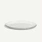 A white oval serving platter with a thin dark blue rim, photographed on a clean off-white background.