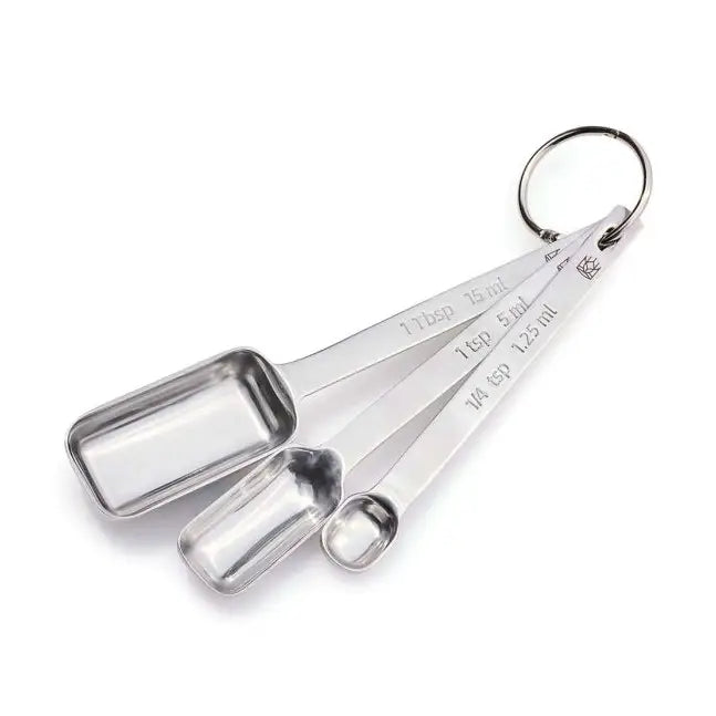 Three stainless steel measuring spoons nested together on a white background, attached to a metal key ring. The spoons are engraved with measurements including 1 tbsp (15 ml), 1 tsp (5 ml), and 1/4 tsp (2.