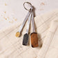 Set of four measuring spoons with spices on a textured surface