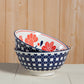 Two ceramic bowls with floral patterns stacked on a wooden surface.