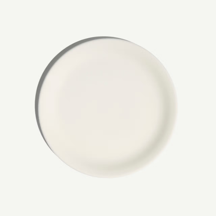 Round white object with a metallic rim on a light gray background
