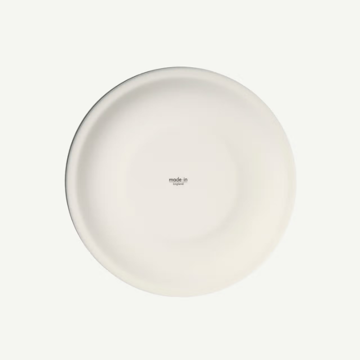 A minimalist white ceramic plate with a small 'made in ITALY' print in the center, shown from a top-down view on a light off-white background.