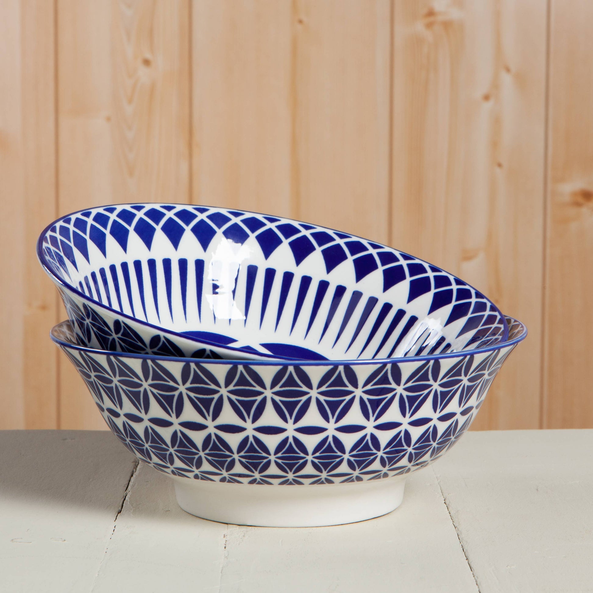 Two blue and white patterned ceramic bowls on a wooden surface.