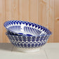 Two blue and white patterned ceramic bowls on a wooden surface.