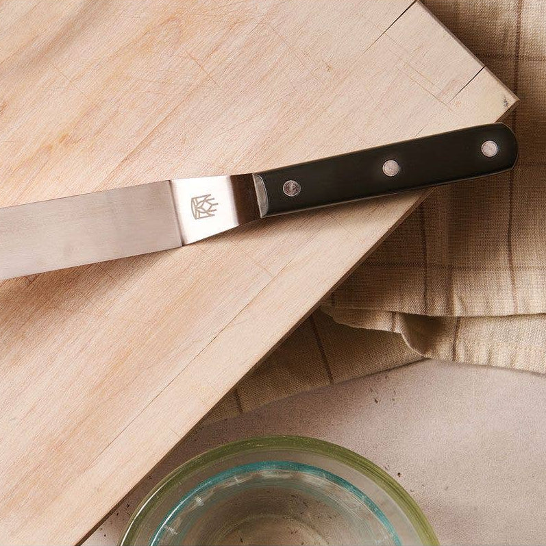 Knife with a black handle on a wooden cutting board