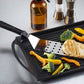Grill pan with vegetables and a spatula on a light surface